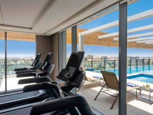 吉达Swissotel Living Jeddah的一个带跑步机和游泳池的健身房