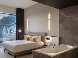 那慕尔Mercure Namur Hotel的酒店客房配有一张床和浴缸。
