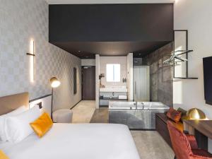 那慕尔Mercure Namur Hotel的一间带大床的卧室和一间浴室