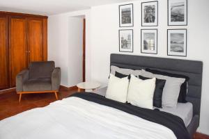 巴拿马城Amazing Loft with the Best view of Casco viejo!的一间卧室配有一张床和一把椅子,墙上挂着图片