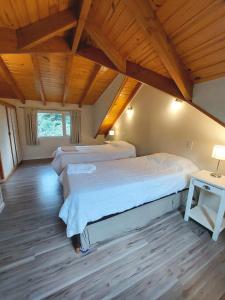 拉安戈斯图拉镇Cabaña Los Amancays的一间卧室设有两张床和木制天花板