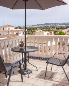 哈维亚Casa Valentina的阳台配有桌椅和遮阳伞