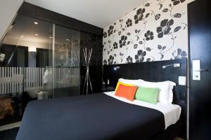 丰沙尔丰沙尔设计酒店的一间卧室配有一张带色彩缤纷枕头的大床