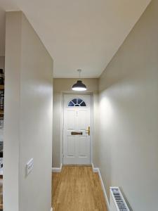 特伦特河畔斯托克Joshua Court Single Room的走廊上设有白色门和窗户