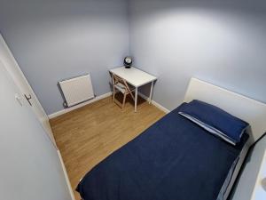 特伦特河畔斯托克Joshua Court Single Room的小房间设有一张床和一张桌子