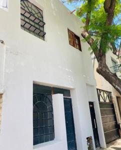 布宜诺斯艾利斯Mini house con sol y luz的白色的房子,有一扇门和一棵树