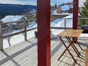 Ängena5 person holiday home in TEGEFJ LL的地面上积雪的甲板上的木桌