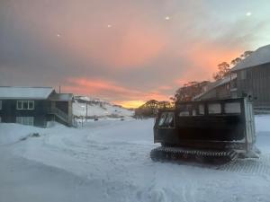 佩里舍峡谷流浪汉小屋酒店的日落时分,推土机沿着雪覆盖的街道行驶