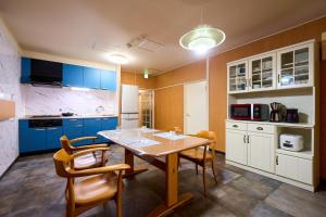 东京羽田雷克斯公寓的厨房配有蓝色橱柜和桌椅