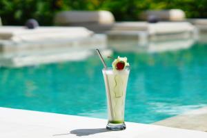 塞隆贝拉纳克Amazing Lombok Resort的坐在游泳池旁喝一杯樱桃