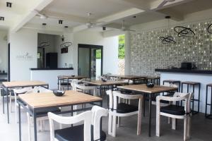 塞隆贝拉纳克Amazing Lombok Resort的配有木桌和白色椅子的餐厅