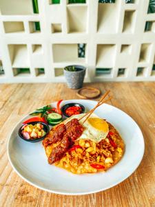 塞隆贝拉纳克Amazing Lombok Resort的桌上的鸡蛋香肠和蔬菜等食物
