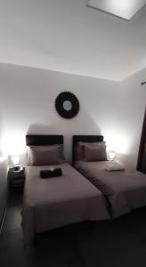 帕皮提PAMATAI COSY LODGE的一间卧室设有两张床,墙上设有一面镜子