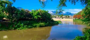 琅勃拉邦Ban Lakkham River View的一条有树木和山脉的河流