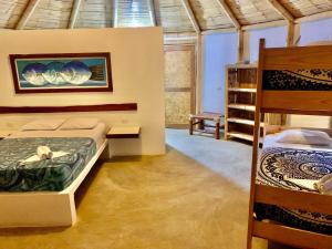 卡诺阿斯德蓬萨尔Waltako Beach Culture的一间卧室配有两张床和一张双层床。