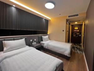 香港Hennessy Hotel的酒店客房带两张床和一间浴室