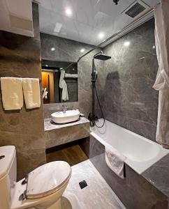 香港Hennessy Hotel的浴室配有卫生间、盥洗盆和浴缸。