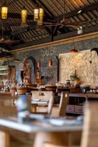 金巴兰Jimbaran Puri, A Belmond Hotel, Bali的一间在房间内配有桌椅的餐厅