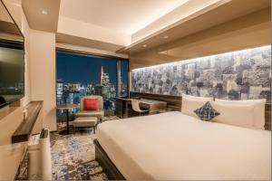 东京THE BLOSSOM HIBIYA的酒店客房享有城市美景,配有一张床。