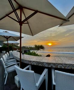 蓝梦岛棕榈金银岛酒店的海滩酒吧设有白色椅子和遮阳伞