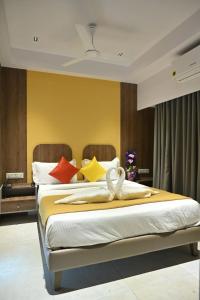 拉杰果德Hotel The Faam的一间卧室配有两张带色彩缤纷枕头的床