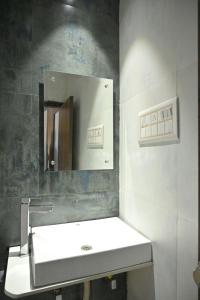 拉杰果德Hotel The Faam的浴室设有白色水槽和镜子
