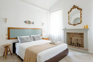 蒙特奇奥艾米利亚La Casa sulle Mura的一间白色卧室,配有一张床和一个壁炉