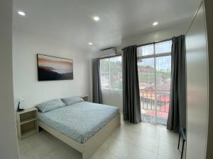 卡塔海滩Shaka Guest House的一间卧室设有一张床和一个大窗户