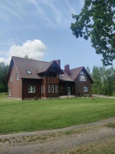 普伦盖Stay at Svaja的一个大棕色房子,有大草地庭院