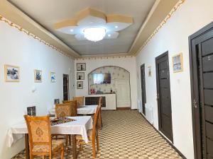 希瓦Gold Khiva的一间带桌椅和天花板的用餐室