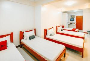 黎牙实比RedDoorz S&L Apartelle Daraga Albay的一间设有三张白色和红色床铺的房间