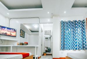 黎牙实比RedDoorz S&L Apartelle Daraga Albay的一间设有床铺和电视的房间