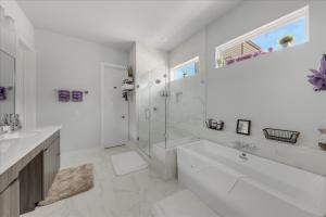 休斯顿Azaliah Luxe Connection的白色的浴室设有浴缸和水槽。