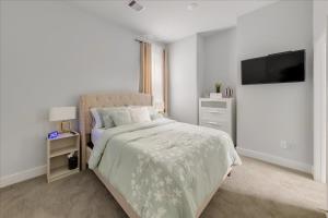 休斯顿Azaliah Luxe Connection的白色卧室配有床和平面电视
