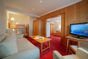 费尔兹姆斯Hotel Alpenblick的客厅配有白色沙发和电视