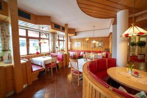 费尔兹姆斯Hotel Alpenblick的餐厅设有红色的椅子和桌子以及窗户。