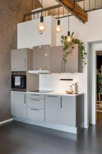 克里斯蒂安桑1-Roms toppleilighet på tangen/bystranda的厨房配有白色橱柜和炉灶。
