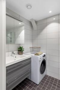 克里斯蒂安桑1-Roms toppleilighet på tangen/bystranda的一间带洗衣机和水槽的浴室