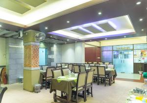吉大港Hotel Golden Inn Chattagram Ltd的一间在房间内配有桌椅的餐厅
