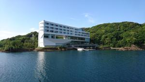 SaikaiOliveBay Hotel的湖上一座建筑物,水中有一条船