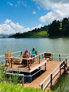 卡巴莱Lake Bunyonyi Rock Resort的两人坐在湖上的一个码头上