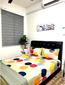 Kampong ChinchangHomestay Ika KLIA @ Enstek的一间卧室配有一张带五颜六色棉被的床