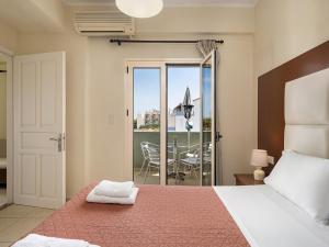 卡拉马基索非亚公寓酒店的一间卧室配有一张床,阳台配有桌子