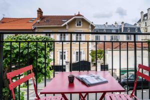 比亚里茨Urban Style Biarritz Le Relais的阳台上的红色桌子和书