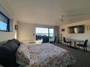 PureruaMakuri Bay Hideaway的一间卧室配有一张床、一张桌子和一个窗户。