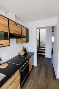 萨摩斯Passatempo Apartment Ireon的厨房配有黑色台面和木制橱柜