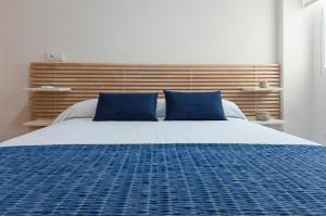 甘迪亚Ag Aiguablava的一间卧室配有一张带蓝色枕头的大床