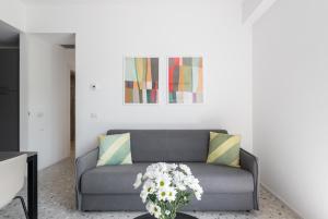罗马numa I Verso Apartments的客厅配有带鲜花的沙发的桌子