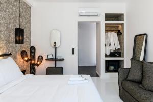 米克诺斯城She Mykonos - The Residency的卧室配有白色的床和椅子