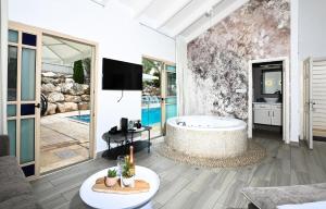 提比里亚YalaRent Liri Resort - a beautiful resort complex in Tiberias的带浴缸的大型浴室和电视。